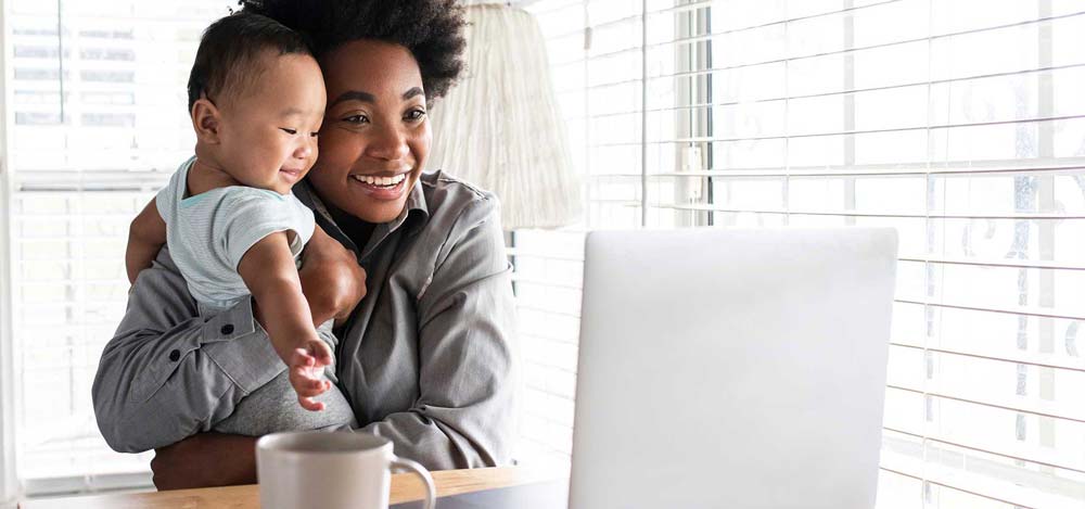 Mother and baby using internet on laptop